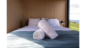 a bed with two rolled up towels on it at Aorangi Peak Cabins 4 by Tiny Away in Rotorua