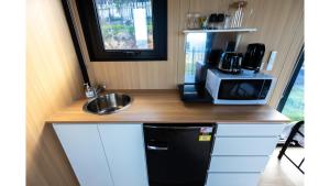 a small kitchen with a sink and a microwave at Aorangi Peak Cabins 4 by Tiny Away in Rotorua