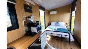 a small bedroom with a bed in a tiny house at Aorangi Peak Cabins 4 by Tiny Away in Rotorua