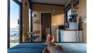 a person laying on a bed in a rv at Aorangi Peak Cabins 4 by Tiny Away in Rotorua