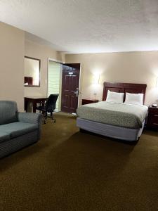 Una habitación de hotel con una cama, una silla y un escritorio. en Economy Inn, en Portland