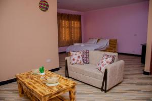 a living room with a couch and a table and a bed at One bedroom Dodoma in Dodoma