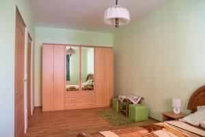 a bedroom with a pink door and a mirror at Tisza-Tavirózsa Vendégház in Tiszaszőlős