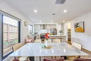 una cucina e una sala da pranzo con tavolo e sedie di StayAU Officer Newly 5BRM Homley Villa House a Officer