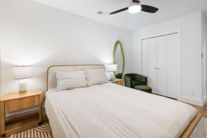 a white bedroom with a bed and a ceiling fan at Stylish Austin Escape 4BR, 2BA, Minutes from Domain, Q2 Stadium in Austin