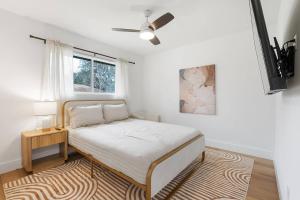 a white bedroom with a bed and a window at Stylish Austin Escape 4BR, 2BA, Minutes from Domain, Q2 Stadium in Austin