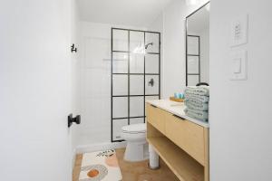 a bathroom with a toilet and a sink with a mirror at Stylish Austin Escape 4BR, 2BA, Minutes from Domain, Q2 Stadium in Austin