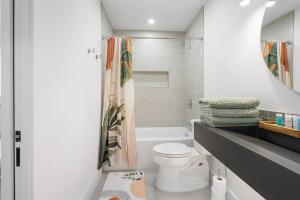 a white bathroom with a toilet and a sink at Stylish Austin Escape 4BR, 2BA, Minutes from Domain, Q2 Stadium in Austin