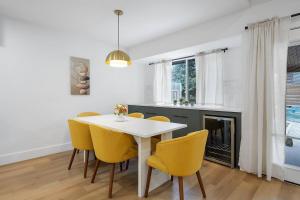 a dining room with a white table and yellow chairs at Stylish Austin Escape 4BR, 2BA, Minutes from Domain, Q2 Stadium in Austin