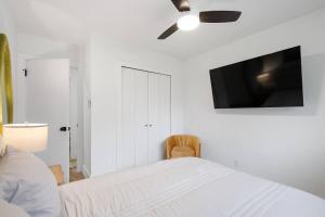 a bedroom with a bed with a ceiling fan and a tv at Stylish Austin Escape 4BR, 2BA, Minutes from Domain, Q2 Stadium in Austin