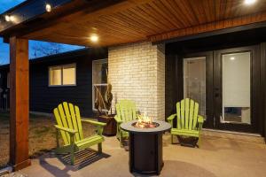 a patio with three chairs and a table with a fire at Stylish Austin Escape 4BR, 2BA, Minutes from Domain, Q2 Stadium in Austin