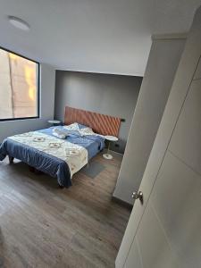a bedroom with a bed and a table in it at Alojamiento a pasos de Movistar Arenas, Universisdad de Chile y Parque O Higgins in Santiago