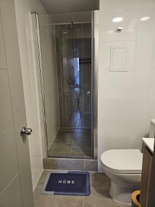 a bathroom with a shower with a home sign on the floor at Alojamiento a pasos de Movistar Arenas, Universisdad de Chile y Parque O Higgins in Santiago