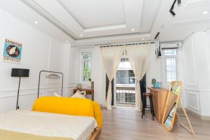 - une chambre avec un lit jaune et un bureau dans l'établissement NamiStay Sài Gòn Central Home, à Hô-Chi-Minh-Ville