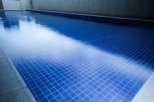 una piscina con azulejos azules en el suelo en Sapphire Seaview Park Suites near Okada, Solaire, MOA, NAIA Airport, Bayview, en Manila