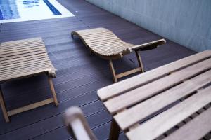 Dos bancos de madera sentados al lado de una mesa y una mesa y una mesa en Sapphire Seaview Park Suites near Okada, Solaire, MOA, NAIA Airport, Bayview, en Manila