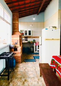 バーハ・デ・サン・ジョアンにあるCasa Aconchegante com Vista para o Mar em Rio das Ostrasのキッチン(冷蔵庫、テーブル付)