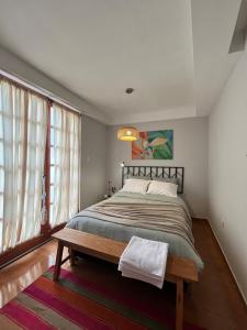 Un dormitorio con una cama grande y una ventana. en Cozy stay with private garden in Taray Pisac, en Taray