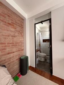 baño con pared de ladrillo y aseo en Cozy stay with private garden in Taray Pisac, en Taray 10 fotos más