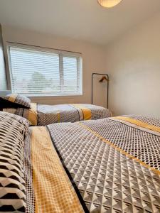 two beds in a room with a window at Long Stay Basildon Essex Business Contractors in Basildon