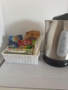 a basket of snacks next to a tea kettle at Pearl of the City TROPICAL PEARL in Kingston