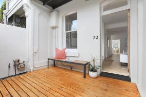 a living room with a bench on a wooden floor at 3 Bedroom Split level terrace at Bondi Junction in Sydney +12 photos