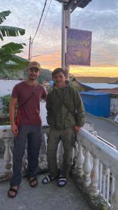 two men standing next to a railing on a bridge at 88HappyHomestay in Luwuk