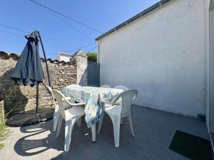 a table and chairs and an umbrella on a patio at Maison calme Saint-Denis d'Oléron proche centre et plage - FR-1-246A-364 in Saint-Denis-dʼOléron