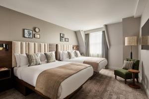 a hotel room with two beds and a chair at Hotel Indigo Leeds by IHG in Leeds +113 photos