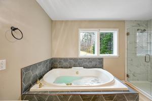 a large bath tub in a bathroom with a window at Lka Luxury Sandy Beach, Sauna, Hot Tub, Firepit in Bumpass +59 photos