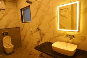 a bathroom with a sink and a toilet and a mirror at Hotel river view sringeri in Sringeri +10 photos