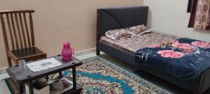 a bedroom with a bed and a table with a vase on it at Gangaji nivas Gest Room in Belgaum