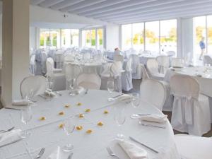 a room filled with white tables and chairs with glasses and napkins at Pietrabianca Exclusive Resort in Pomigliano dʼArco +15 photos