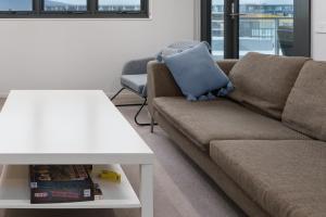 a living room with a couch and a table at Convenient City Apartment in the Heart of Braddon - Hosted by Canstay in Braddon