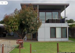 een huis met een boom ervoor bij Camelot in Kingscote