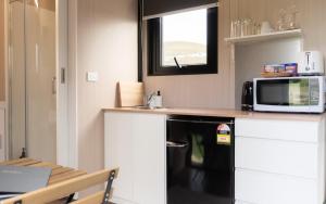 a small kitchen with a microwave and a counter top at Weka Pass Cottages 2 by Tiny Away in Waikari