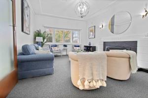 a living room with two chairs and a fireplace at Santa Maria - Saltwater Pool, Exquisite Style in Wagga Wagga +19 photos