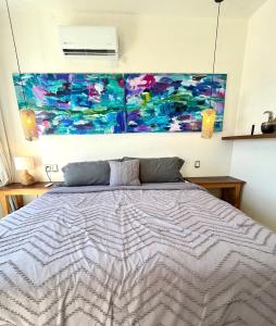 a bedroom with a bed and a painting on the wall at Casa Mantra Ocean View & Private Terrace in La Ventana