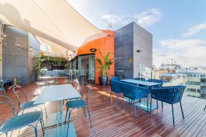 a balcony with tables and chairs on a building at Hotel Indigo Madrid - Gran Vía by IHG in Madrid