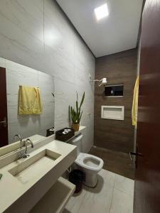 a bathroom with a sink and a toilet in it at Casa linda em Goianésia! in Goianésia