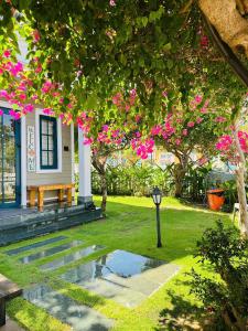 a house with a garden with pink flowers at AnnA Villa - Novaworld Phan Thiết in Bình Tú