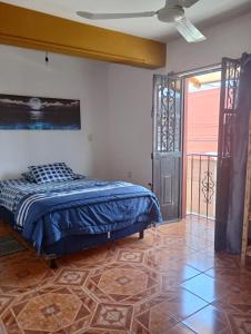 a bedroom with a bed with a blue comforter at Luna y Mar in Oaxaca City