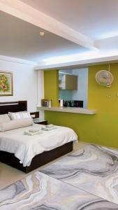 a bedroom with two beds and a green wall at Wan Studiostay by Khalifa Suites in Kota Bharu