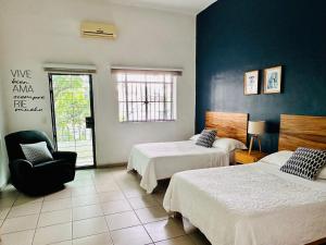 a hotel room with two beds and a chair at Espacio Libertad Colonia Americana in Guadalajara