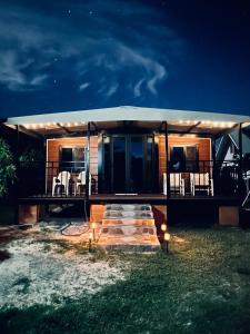 een huis met een verlichte veranda in de nacht bij Nui Stay in Haapiti