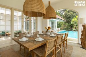 a dining room with a table and chairs and a pool at StayVista at Villa Selene - Dolly J Homes with Pool in Sangolda