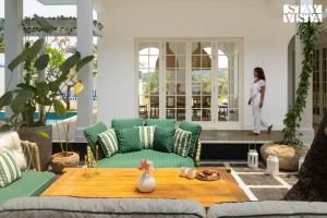 a living room with a couch and a table at StayVista at Villa Selene - Dolly J Homes with Pool in Sangolda
