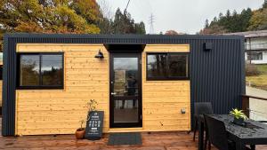 a small black and yellow tiny house on a patio at Nozawa Onsen Tiny Home and Sauna - Mizuho in Iiyama +11 photos