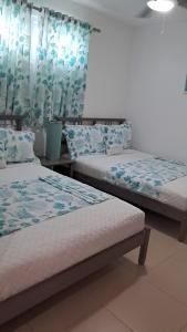two beds in a room with blue curtains at My sun in Juan Dolio +19 photos