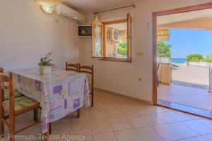 a dining room with a table and a view of the ocean at Zutenica Seaside Residence in Metajna